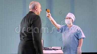 戴着医用口罩的女医生在工作日开始前远程测量男人的体温